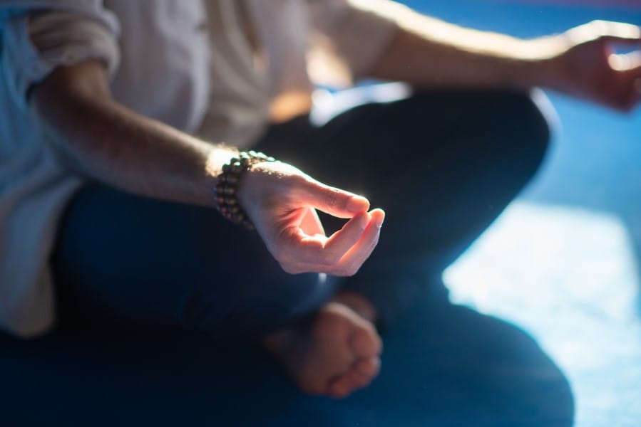 Homem meditando fazendo sinal com as mãos descalço sentado em pose de lótus. Passatempo, espiritualidade, conceito de saúde, Mindfulness.
